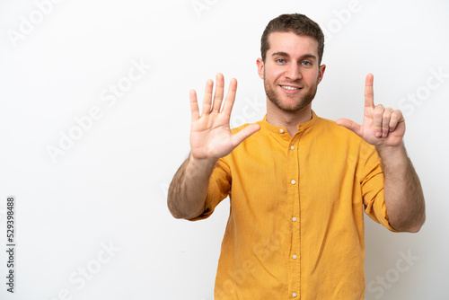 Young caucasian man isolated on white background counting seven with fingers