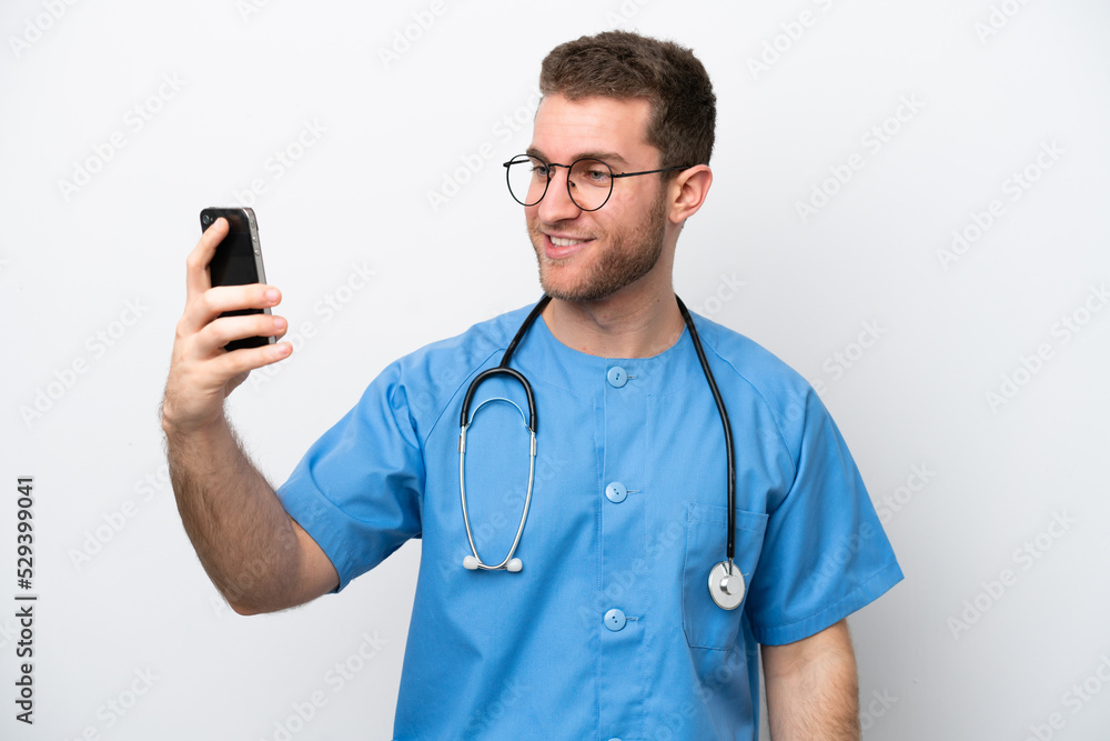 Young surgeon doctor caucasian man isolated on white background making a selfie Young surgeon doctor caucasian man isolated on white background making a selfie