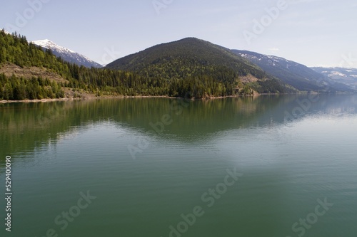 Mountain range by river against clear sky