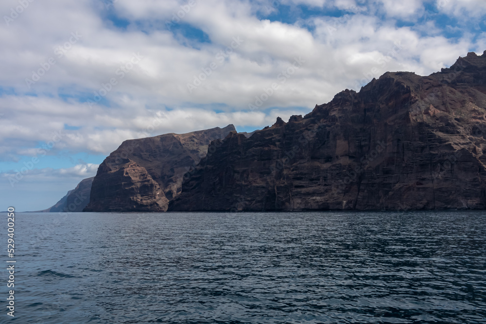 Panoramic view on the massive cliffs of Los Gigantes in Santiago del Teide, Western coast of Tenerife, Canary Islands, Spain, Europe. Rock formations along the coastline of the Atlantic Ocean. Freedom