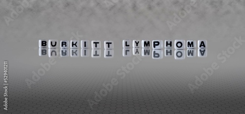 burkitt lymphoma word or concept represented by black and white letter cubes on a grey horizon background stretching to infinity photo