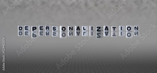 depersonalization word or concept represented by black and white letter cubes on a grey horizon background stretching to infinity