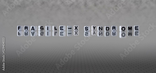 fragile x syndrome word or concept represented by black and white letter cubes on a grey horizon background stretching to infinity