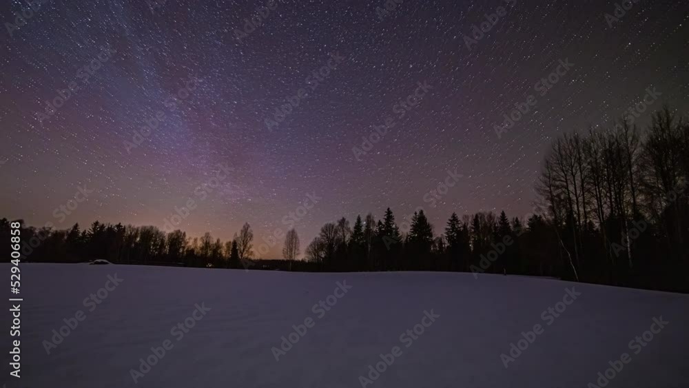 Dreamy night sky time lapse with orbiting stars over snowy woodland Dreamy night sky time lapse with orbiting stars over snowy woodland
