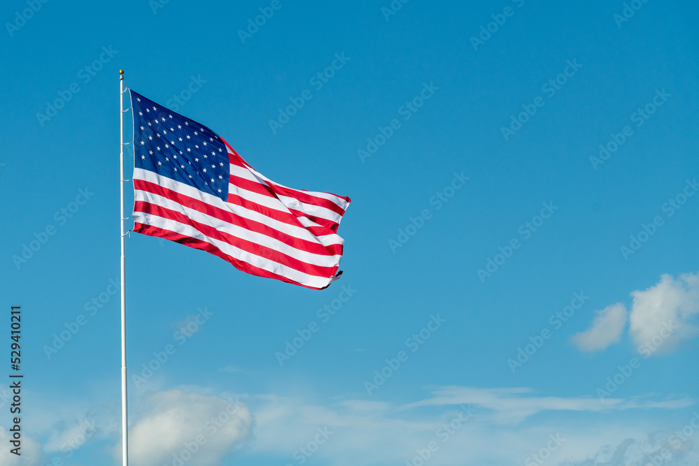 American flag against a blue sky during the summer in Minnesota, USA
American flag against a blue sky during the summer in Minnesota, USA