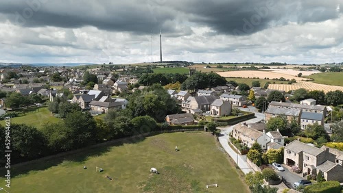 Traditional English village rural scene. Aerial footage of village houses in the town of Emley Huddersfield West Yorkshire. Rural Drone Scene, with Emly Moor Mast in the distance. photo