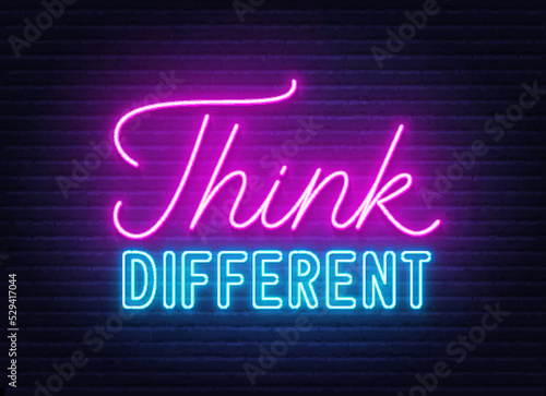 Think Different neon quote on brick wall background.