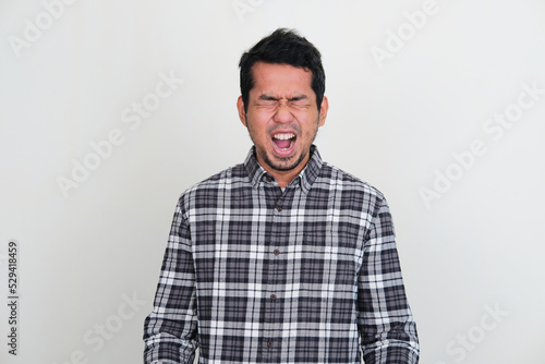 Asian man screaming loud showing stressed expression photo