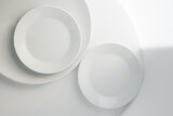 art table setting with minimalistic simple round tableware. Plain empty white plates, top view
