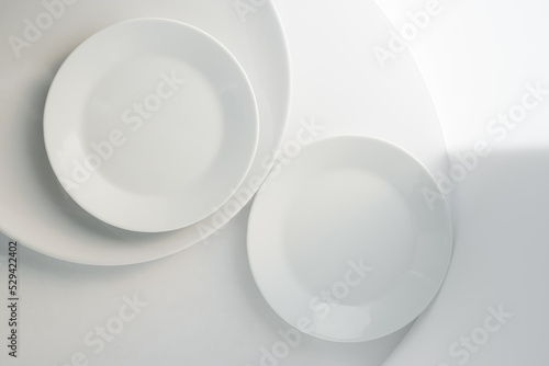 art table setting with minimalistic simple round tableware. Plain empty white plates, top view