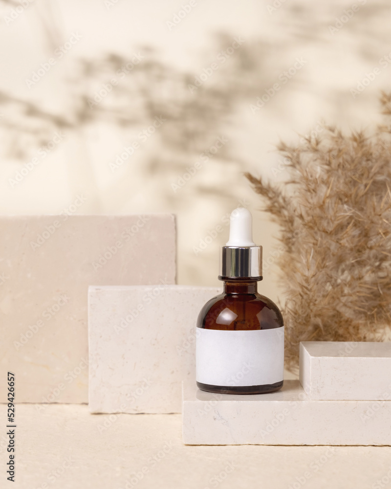 Brown dropper cosmetic bottle with blank label on stones near pampas grass close up, Mockup Brown dropper cosmetic bottle with blank label on stones near pampas grass close up, Mockup
