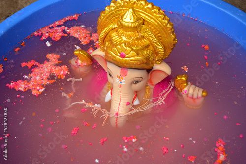 Eco friendly ganpati visarjan at home in plastic tub for save water and environment. Ganpati visarjan in a Plastic tank to save water pollution. photo