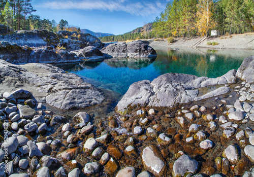 A small lake with amazing water color. Valley of the Katun River, Altai. Warm and sunny autumn day.