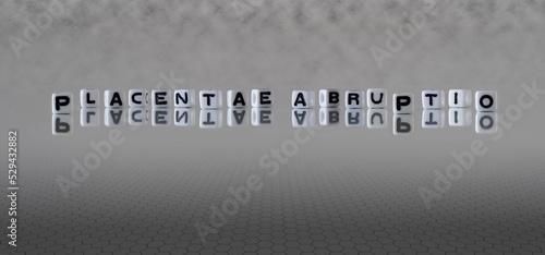 placentae abruptio word or concept represented by black and white letter cubes on a grey horizon background stretching to infinity