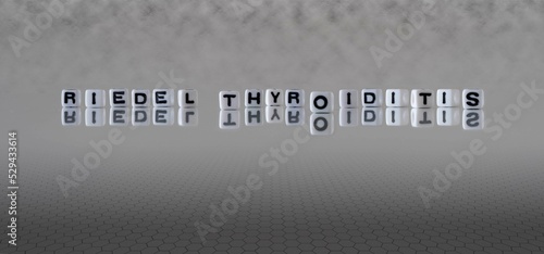 riedel thyroiditis word or concept represented by black and white letter cubes on a grey horizon background stretching to infinity photo