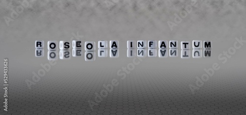 roseola infantum word or concept represented by black and white letter cubes on a grey horizon background stretching to infinity photo