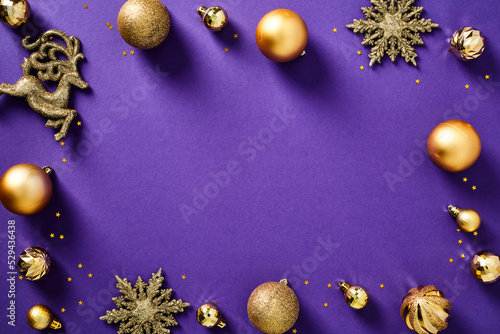 Elegant Christmas background with golden balls and ornaments on purple table. Xmas banner design, New Year greeting card template.