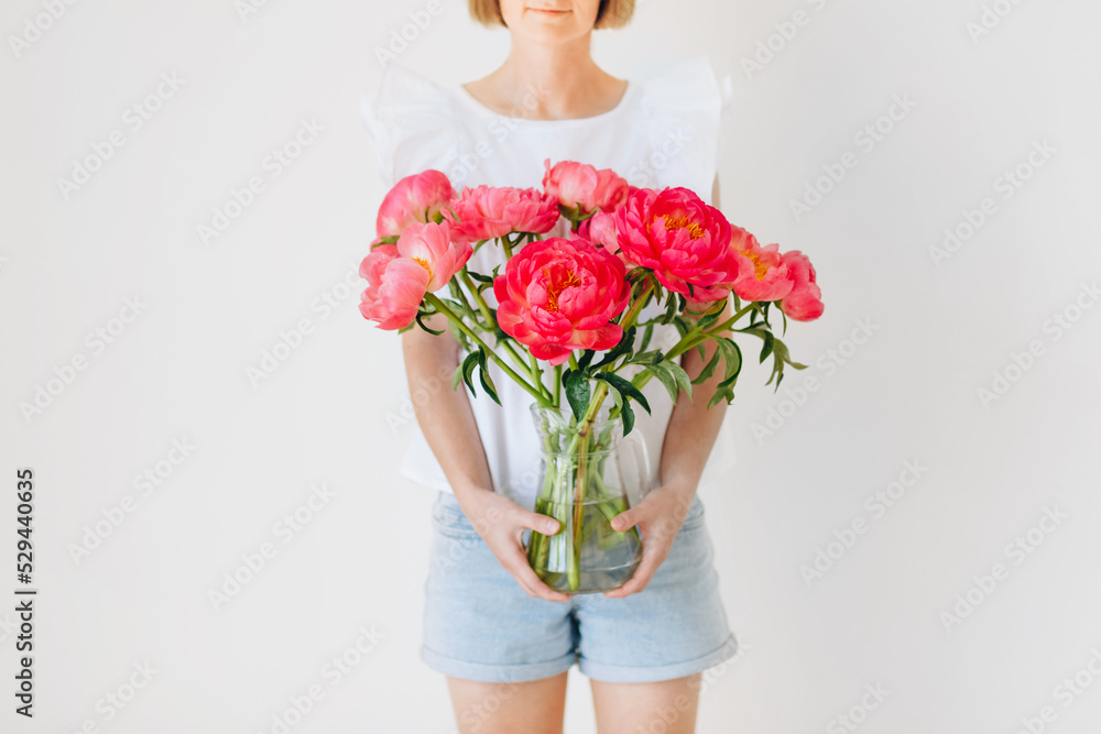 Photo of hipster dreamy girl embracing vase with a huge bouquet of peonies closed isolated turquoise color background Photo of hipster dreamy girl embracing vase with a huge bouquet of peonies closed isolated turquoise color background