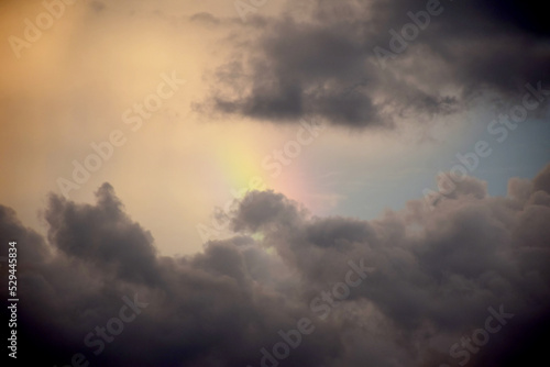 Sunset sky with rainy clouds and rainbow nature background