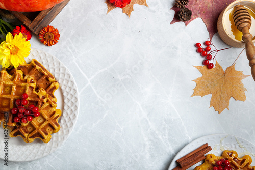food frame for writing text with an autumn still life with pumpkins and waffles. pumpkin waffles on a bright autumn table. autumn, halloween, holidays, holiday, halloween food, autumn menu, concept.