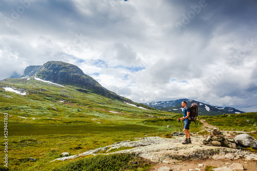 Hiker with backpack standing and enjoying tne view. Norway