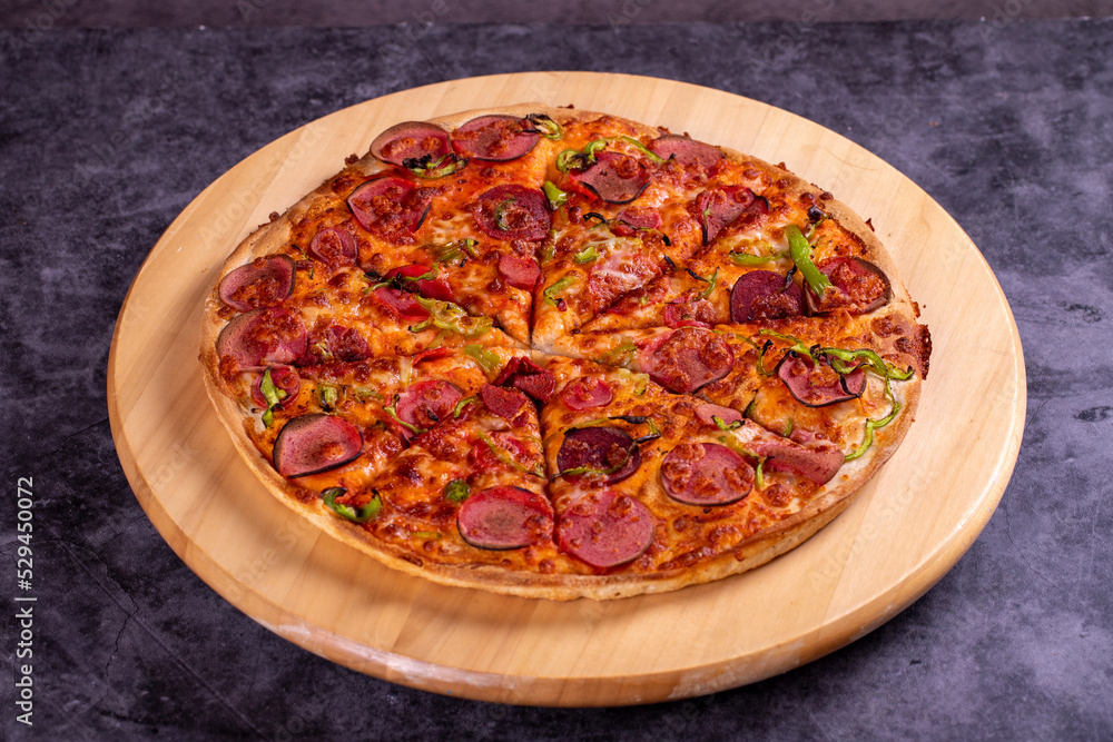 Pizza. Traditional Italian cuisine delicacies. pizza with sausage on dark background