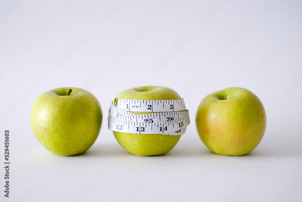Green apple with white measurement tape
