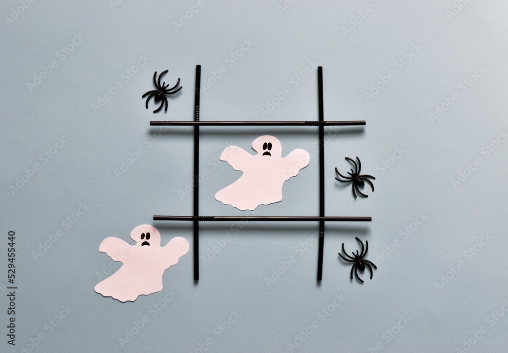 Creative tic tac toe game made of halloween decorations. Ghosts and