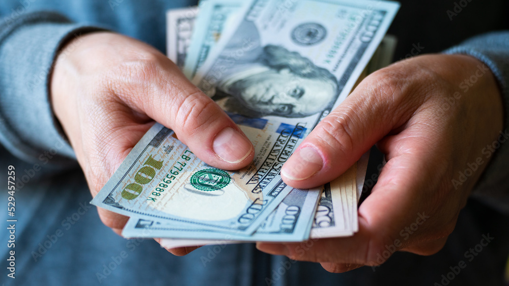 White female model shows dollar bills in her hand closeup front view White female model shows dollar bills in her hand closeup front view