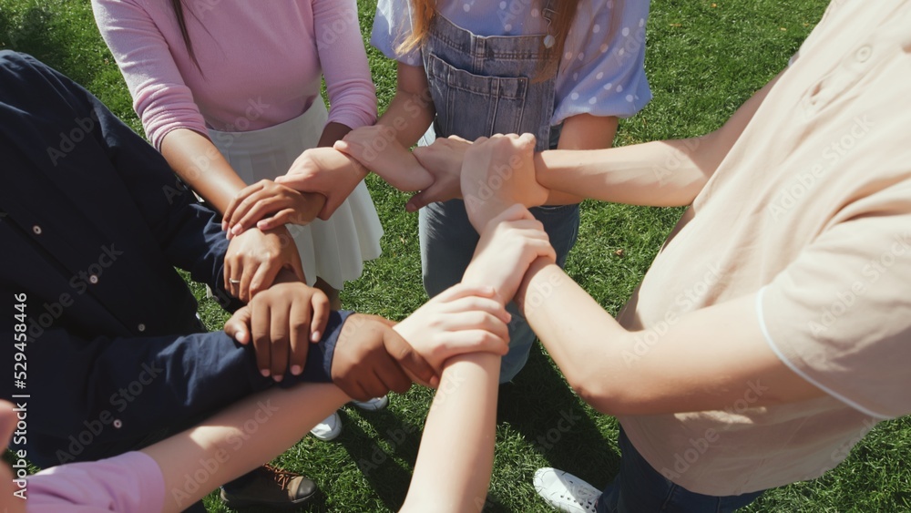 Fototapeta premium Cropped shot of diverse students make circle with hands outdoors