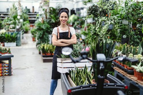 Photography Shot of a young woman working with plants in a garden centre