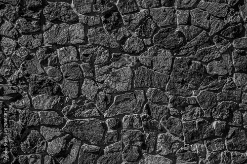 Wall of rough boulders black and white image. Stone masonry.