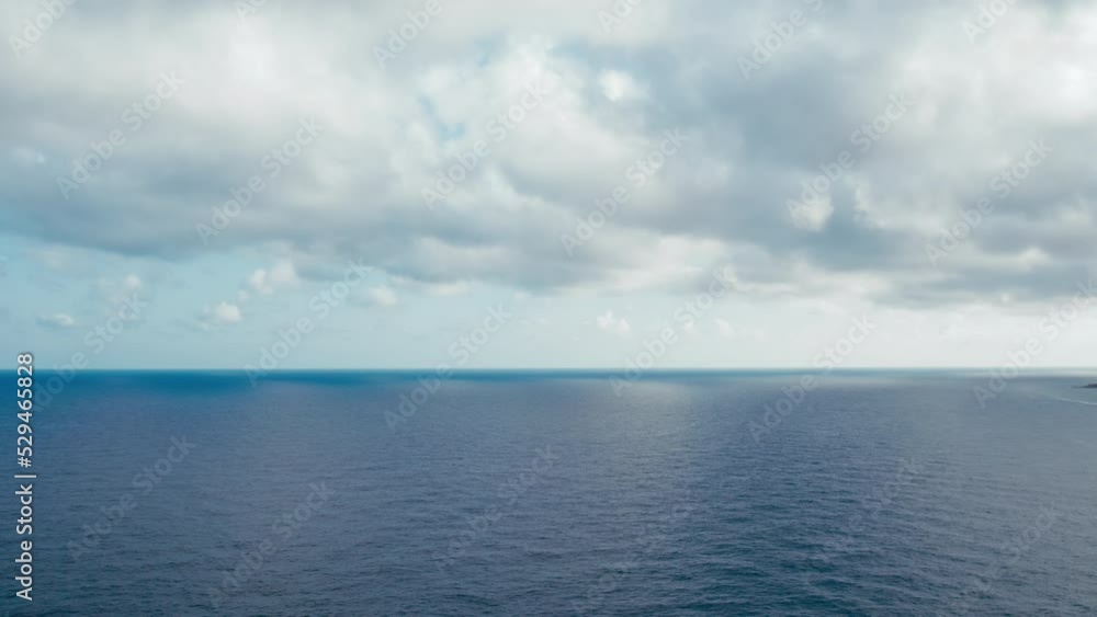 Tracking aerial shot of seascape. Clean image with dramatic overcast sky. White clouds mirrors in blue ocean waters. Idyllic b-roll Tracking aerial shot of seascape. Clean image with dramatic overcast sky. White clouds mirrors in blue ocean waters. Idyllic b-roll