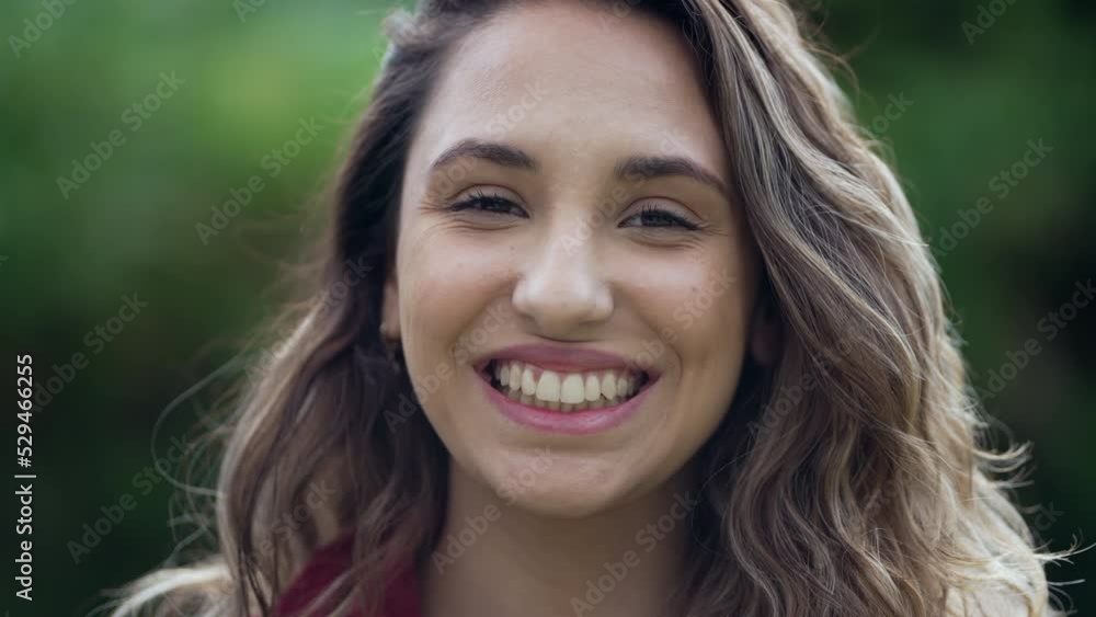 Happy hispanic young woman smiling standing outdoors. One millennial South American girl feeling excited Happy hispanic young woman smiling standing outdoors. One millennial South American girl feeling excited