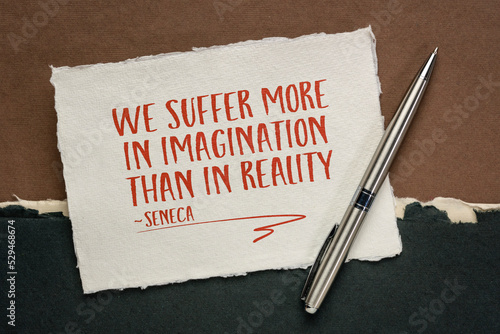 We suffer more in imagination than in reality, Seneca (Roman Stoic philosopher) - handwriting on a white Khadi rag paper against abstract landscape in earth tones, stress and mindset concept photo