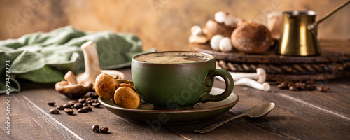 Banner with mushroom coffee in green cup on wooden background. New Superfood trendy healthy concept with copy space, selective focus. photo