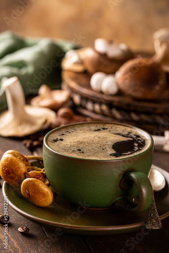 Mushroom coffee in green cup on wooden background. New Superfood trendy healthy concept, selective focus.