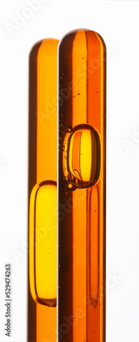 Yellow viscous liquid sunflower lecithin with bubbles in a transparent test tube on a white background