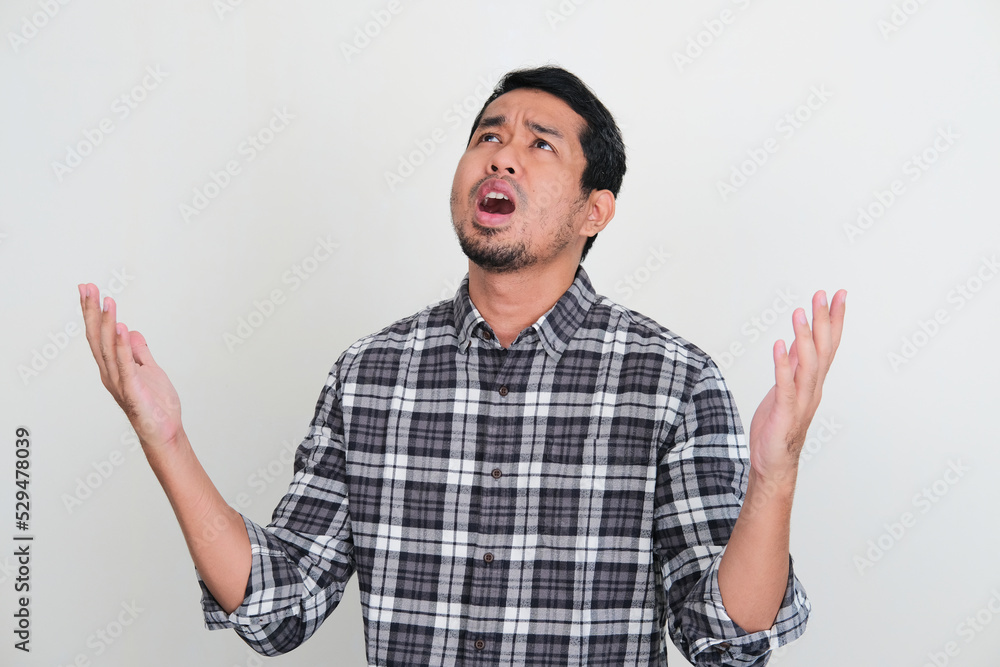 Naklejka premium Asian man looking up showing regret expression