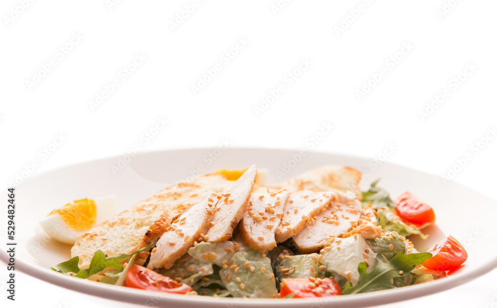 Caesar salad with chicken, white bread croutons, fresh lettuce, tomato and arugula on a white background Caesar salad with chicken, white bread croutons, fresh lettuce, tomato and arugula on a white background