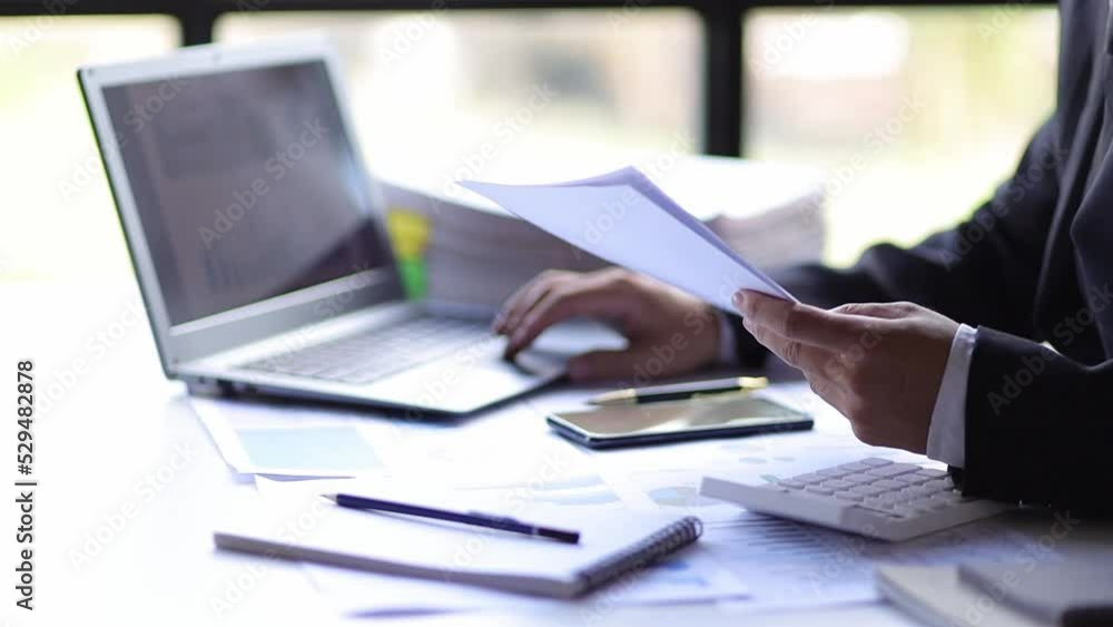 Businessman in office working with financial documents on desk analyzing business marketing growth charts and graphs. Accounting and Financial Planning Businessman in office working with financial documents on desk analyzing business marketing growth charts and graphs. Accounting and Financial Planning