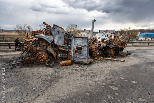 Hostomel, Kyev region Ukraine - 09.04.2022: Burnt military vehicles of Russian soldiers on the bridge across the river. Cars after being hit by rockets, mines. Rusty cars. Charred car parts.