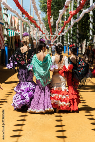 Women in flamenco dresses during fair in city