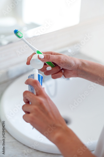 Woman hands holding toothpaste and toothbrush