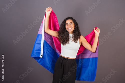 Young Brazilian black woman raising bisexual flag, Bisexual woman, LGBT, LGBTQ photo