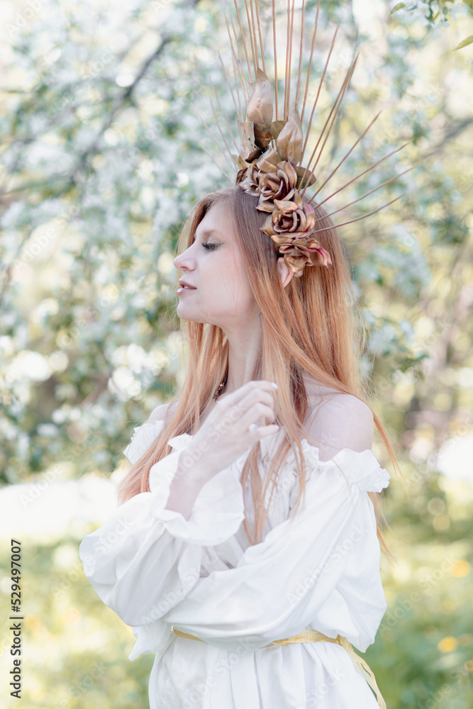 Naklejka premium Bride of the sun in white in the apple trees