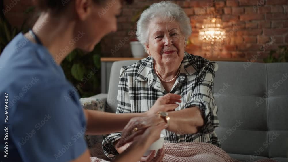 Nurse giving hand massage to happy senior woman in retirement home Nurse giving hand massage to happy senior woman in retirement home