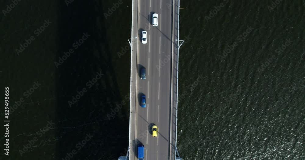 Traffic on cars on the bridge. Aerial top view of traffic on the bridge crossing river. The concept of traffic on the bridge. Traffic on cars on the bridge. Aerial top view of traffic on the bridge crossing river. The concept of traffic on the bridge.