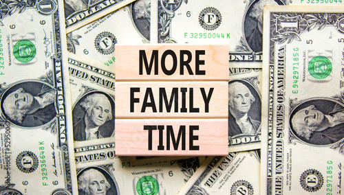 More family time and support symbol. Concept words More family time on wooden blocks on dollar bills. Beautiful background from dollar bills. Business, more family time qoute concept. Copy space.