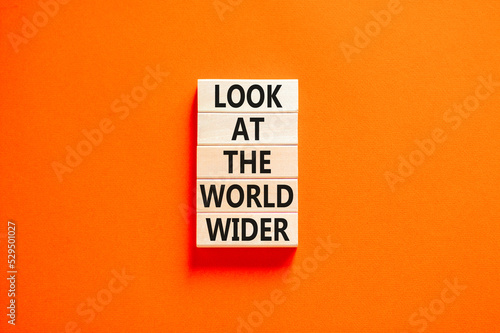Look at the world wider symbol. Concept words Look at the world wider on wooden blocks on a beautiful orange table orange background. Business and look at the world wider concept. Copy space.